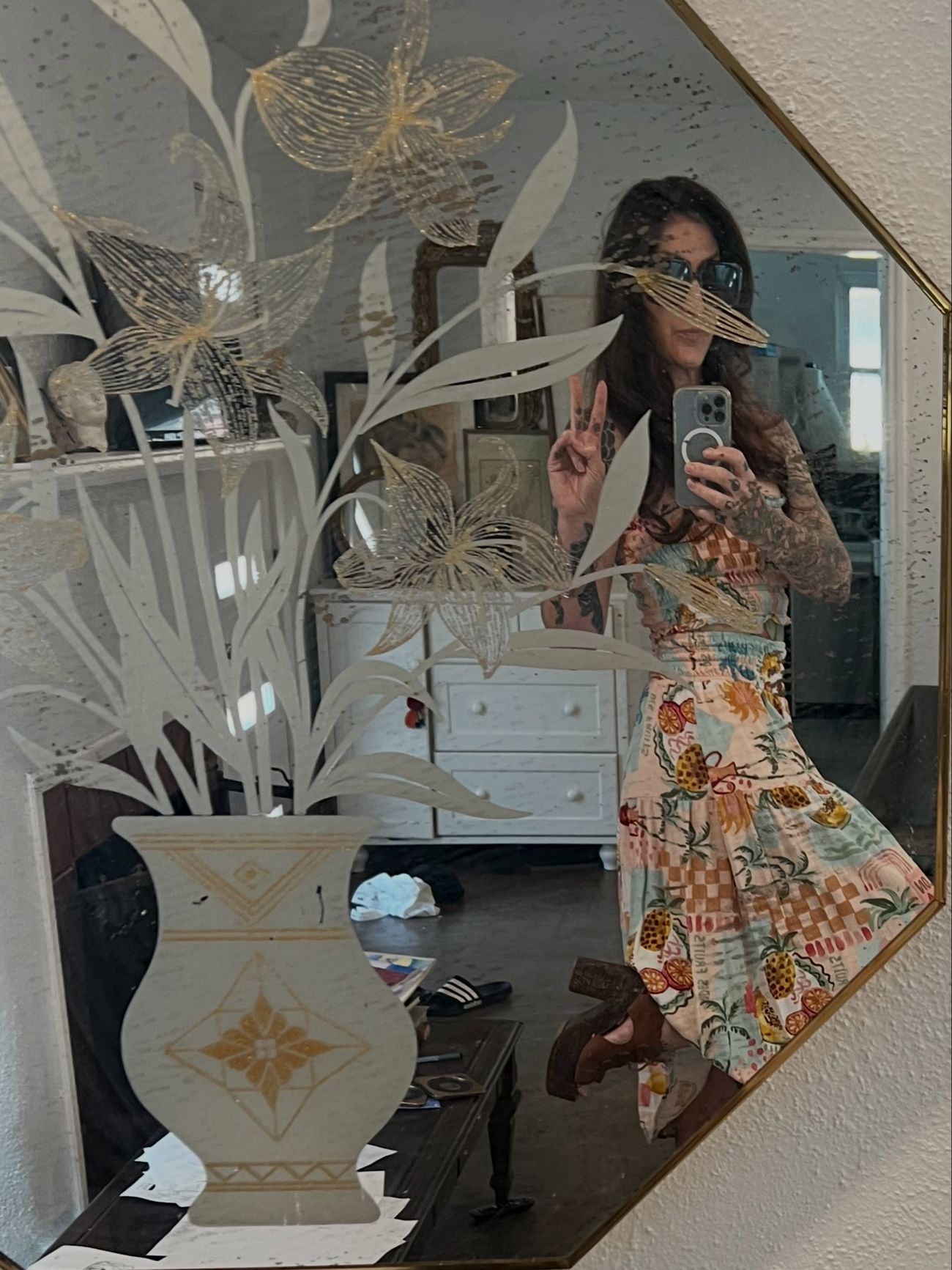 Coley in the studio, surrounded by botanical wallpaper and dried flowers